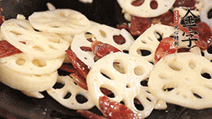 依次下香腸片、藕片翻炒均勻，加適量清水燜熟。