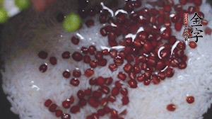 將炒好的食材和大米、紅豆一起放進(jìn)電飯鍋煮。