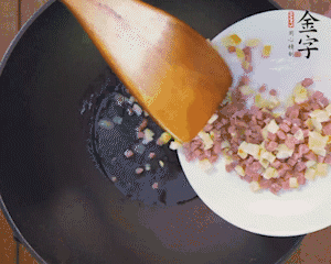 油溫3成熱時(shí)，下火腿丁、筍丁炒出香味，放豌豆粒翻炒均勻2分鐘。