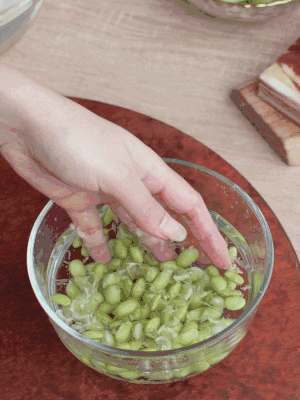 青豆剝殼，搓去外衣。