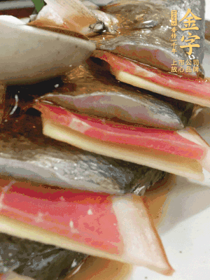 魚肚中塞蔥結(jié)、火腿片，魚身上碼放姜片、火腿片，倒入混合的料汁。
