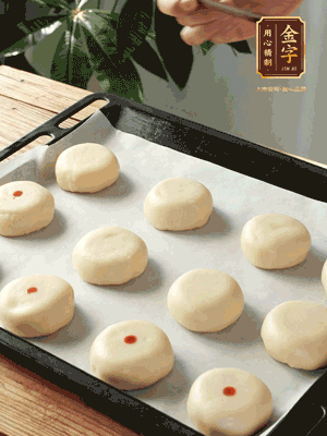 收口向下放在案板上，輕輕將月餅坯按扁，用筷子點紅點做裝飾
