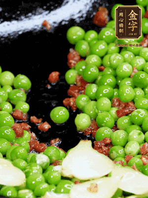 鍋內(nèi)少許油，下火腿煸香，再下甜豆米、百合翻炒，少許鹽、一點(diǎn)水煮到收干