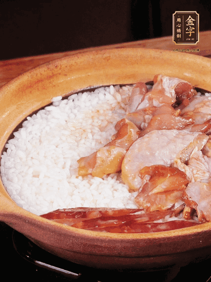 煮到椰子水微微收干轉(zhuǎn)小火，快速均勻鋪上雞肉、金字香腸