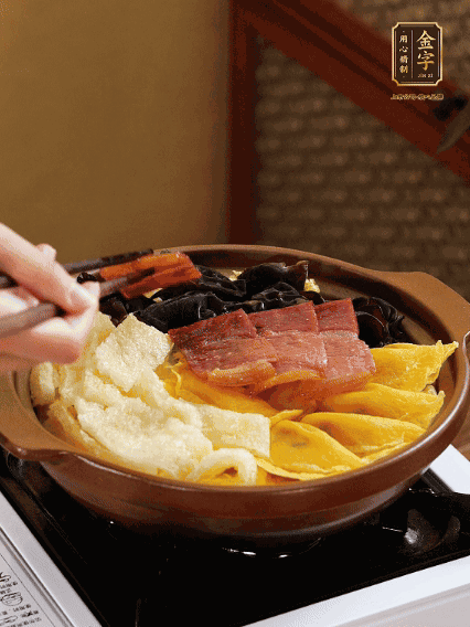 砂鍋底部鋪上娃娃菜，依次擺上肉皮、蛋餃、黑木耳、火腿